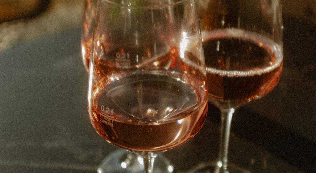 Zwei Gläser Roséwein auf einer dunklen Steinbrüstung
