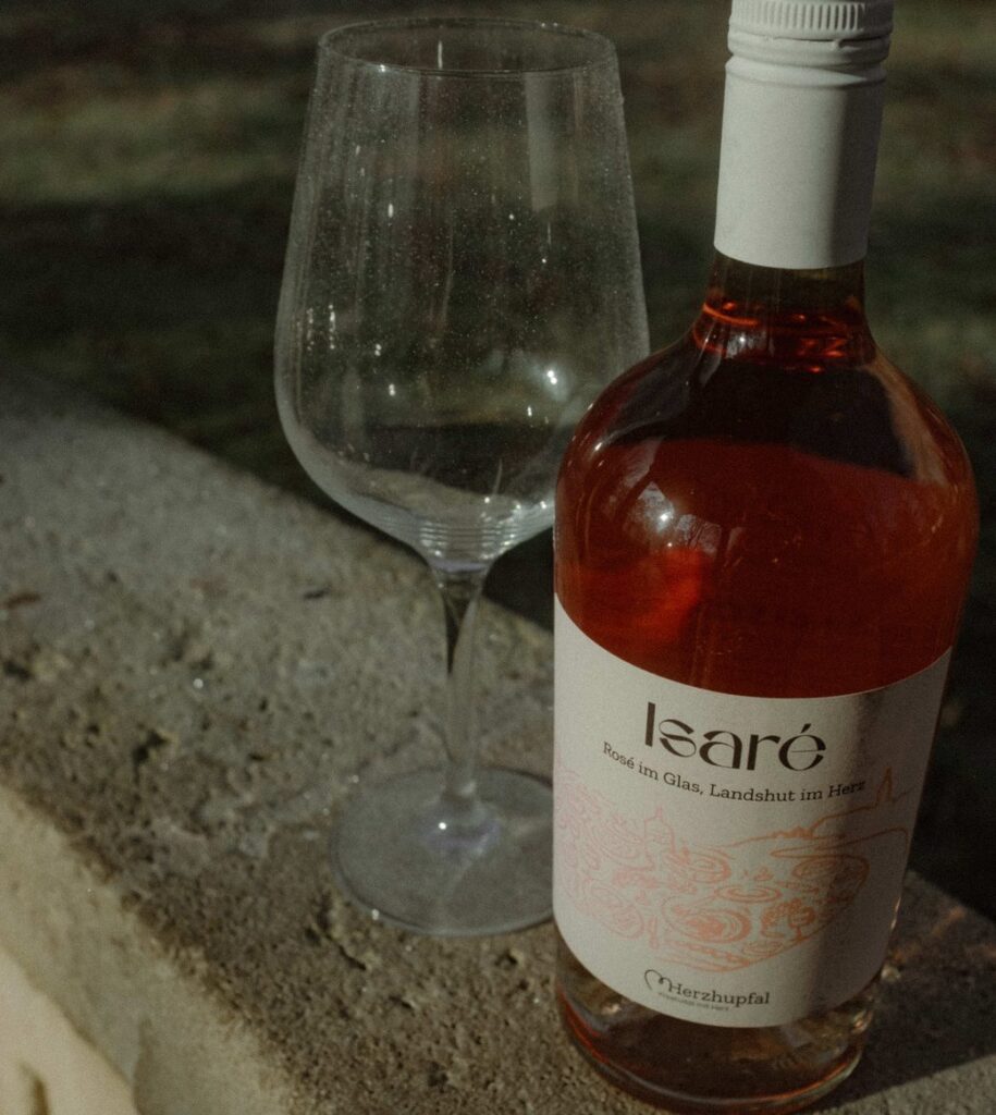Die Isaré-Flasche neben einem leeren Weinglas auf einer Mauer