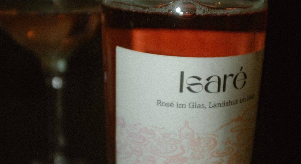Die Isaré-Flasche vor einem gefüllten Weinglas