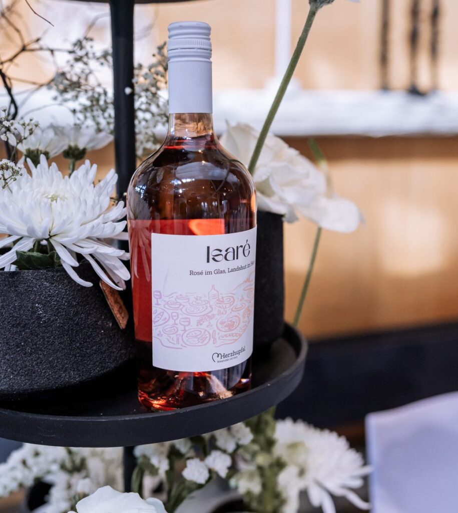 Roseflasche der Marke isare zwischen weissen Blueten